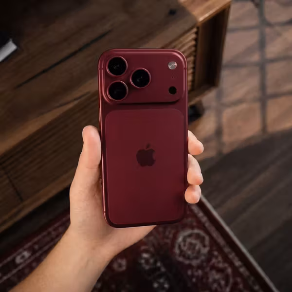 Красный iPhone 15 Pro и Pro Max в руке человека