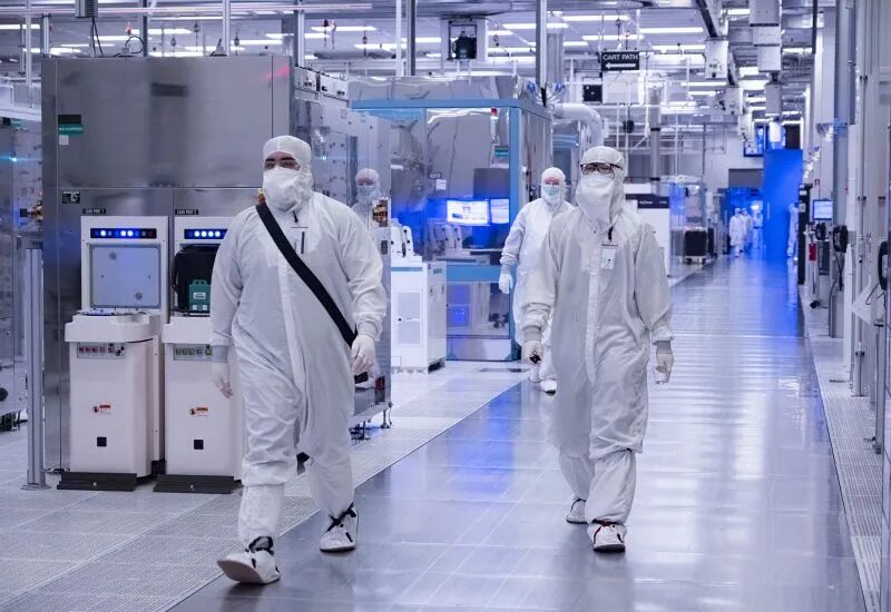 Люди в защитных костюмах на фабрике Intel