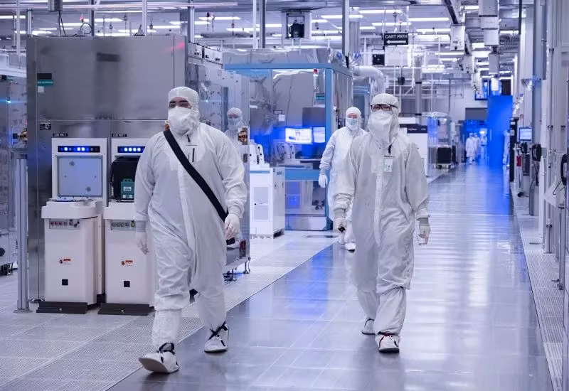 Люди в защитных костюмах на фабрике Intel