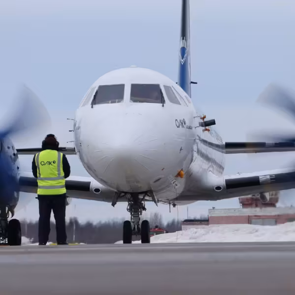 Самолет Ил-114-300 на взлётной полосе с человеком рядом
