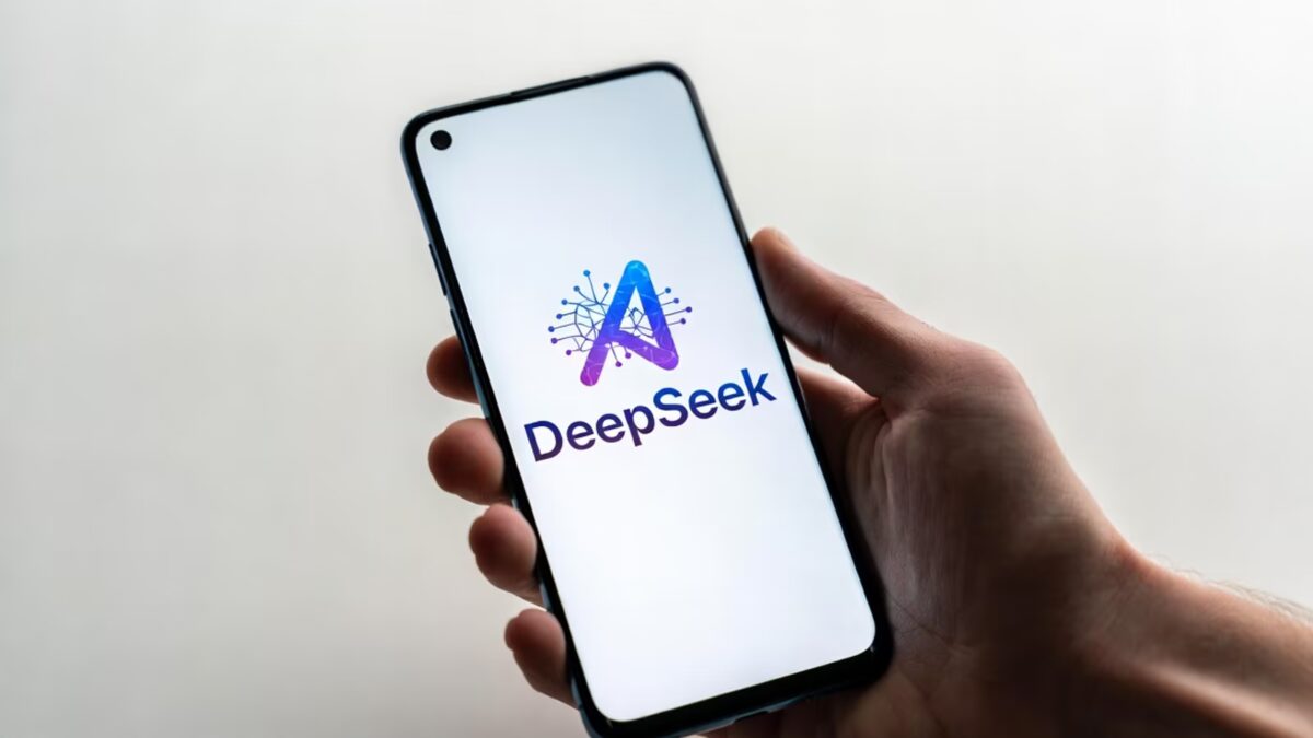 Человек держит смартфон с логотипом DeepSeek