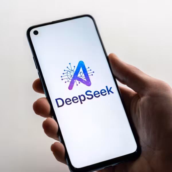 Человек держит смартфон с логотипом DeepSeek