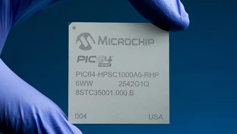 микросхема Microchip PIC64-HPSC1000A0-RHP в руке в голубых перчатках