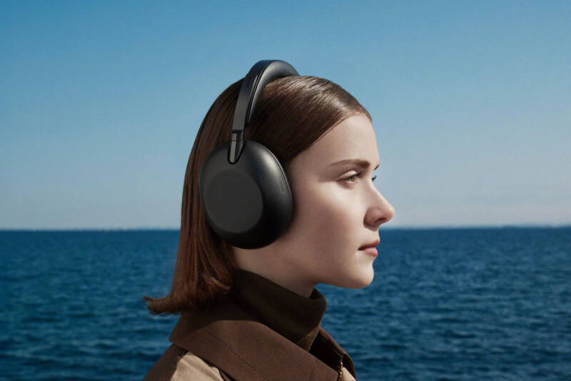 Женщина в наушниках Sony WH-1000XM5 на фоне моря
