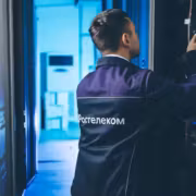 Человек в форме у серверных шкафов Rostelecom РТК-ЦОД
