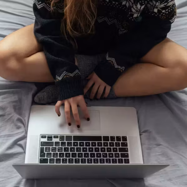 Человек сидит на кровати с ноутбуком Евросоюз VPN