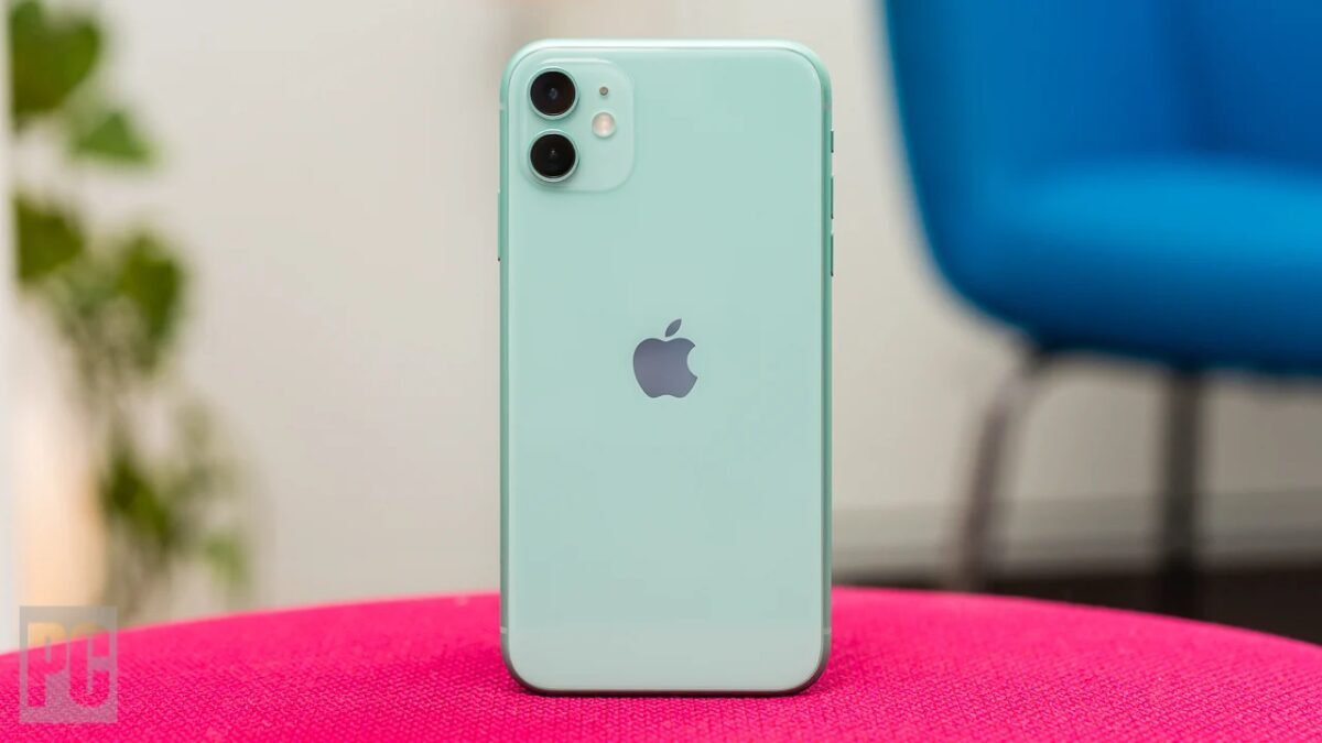 Зеленый iPhone 11 на розовой ткани сзади