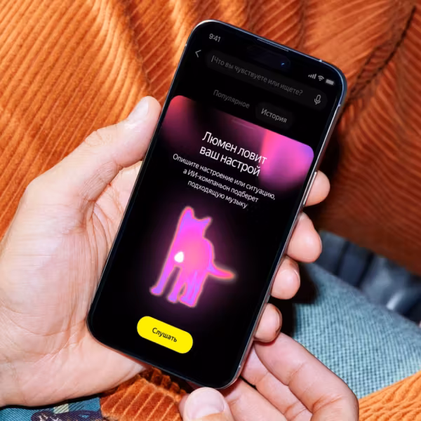 Человек держит iPhone с приложением Яндекс Музыка