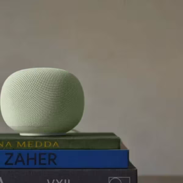 Умная колонка Google Home Speaker на книгах и статуэтке