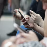 Пользователи смартфонов в очереди на улице, участвуют в акции операторов 5G