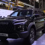 Черный внедорожник Sollers на выставке в цеху