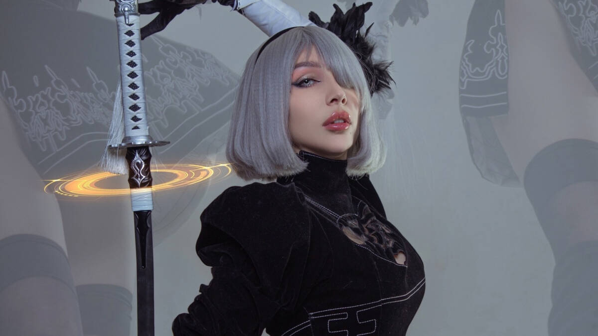 Россиянка в косплей 2B из NieR Automata с серебристыми волосами и мечом