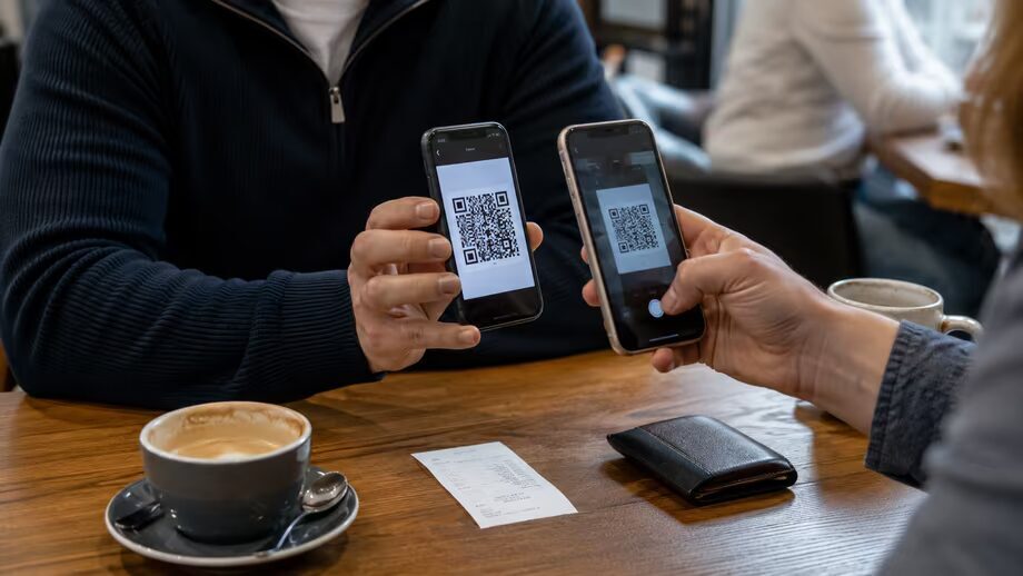 Два телефона показывают QR-код для перевода через ВТБ СБП
