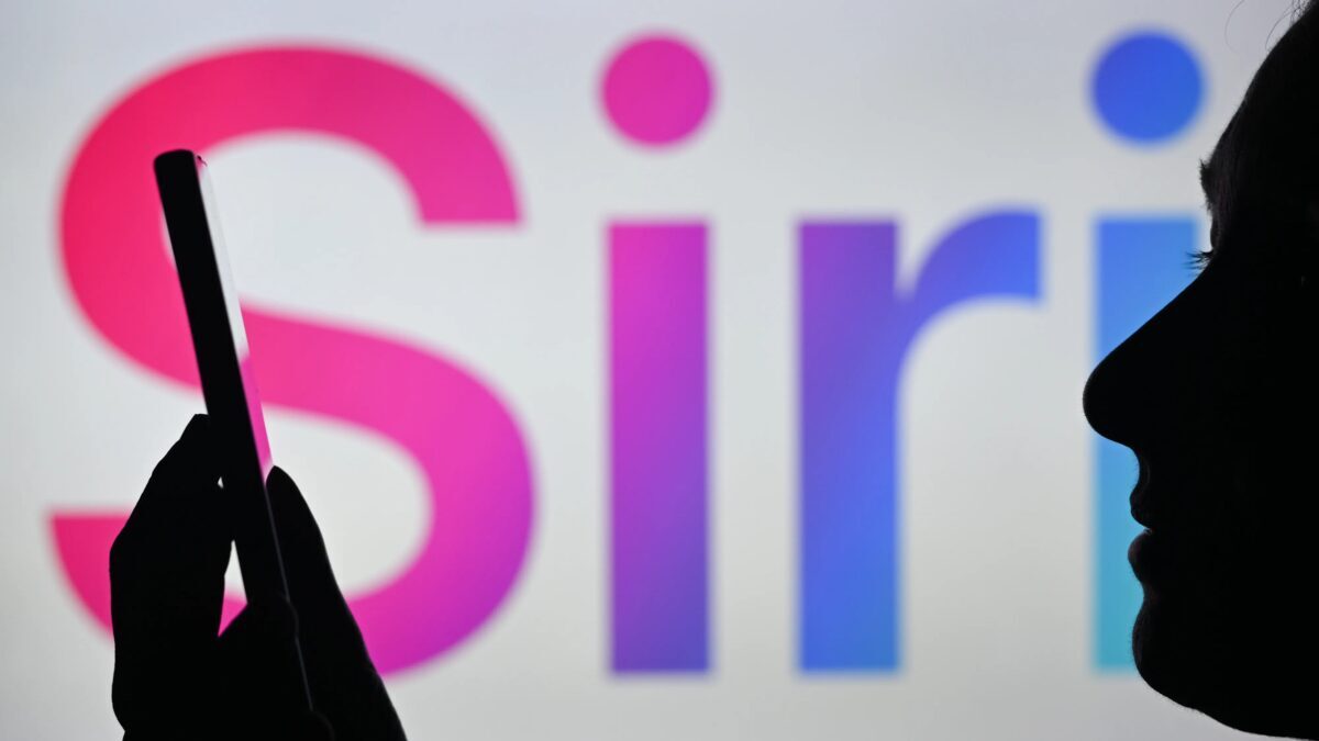 силуэт человека держит смартфон перед экраном Apple Siri AI