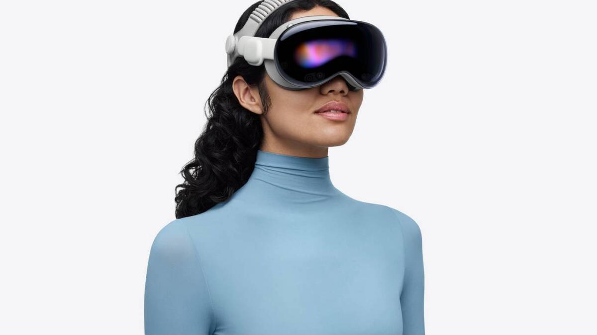 Женщина в голубом жакете с VR очками Apple Vision Pro
