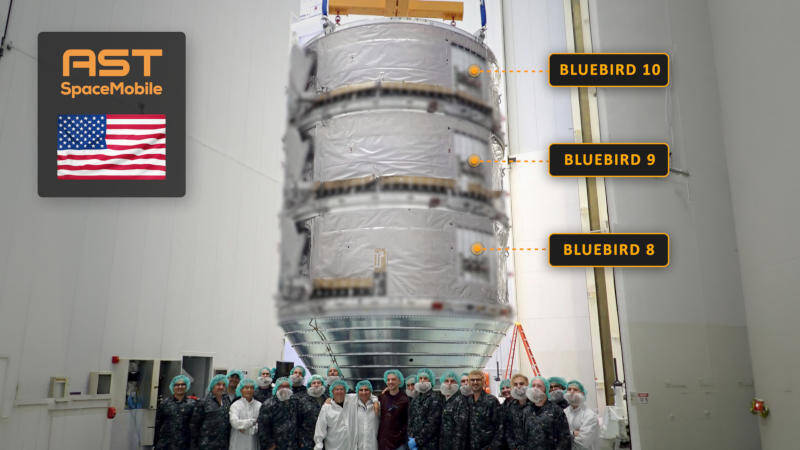 Группа людей в защитной одежде перед крупным спутником BlueBird 8, 9, 10 Astra SpaceMobile