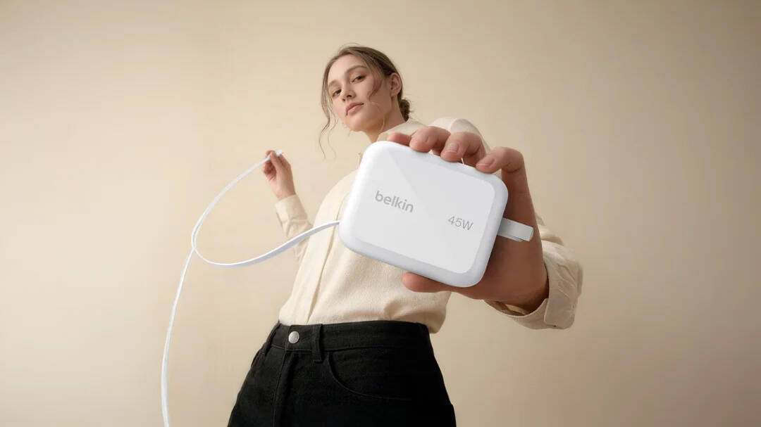 Женщина держит зарядное устройство Belkin с кабелем