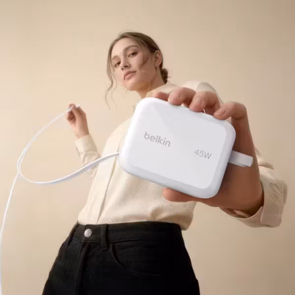 Женщина держит зарядное устройство Belkin с кабелем
