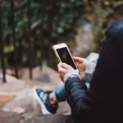 Человек держит смартфон на улице
