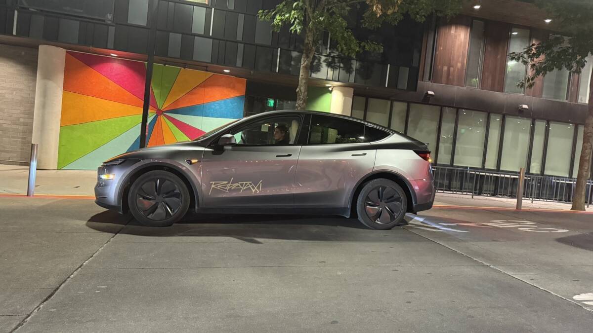 Электрический автомобиль Tesla Robotaxi на улице в городском районе