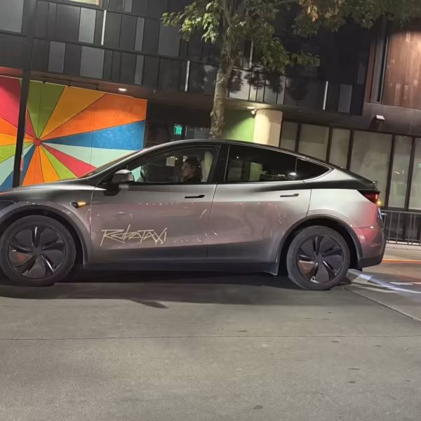 Электрический автомобиль Tesla Robotaxi на улице в городском районе