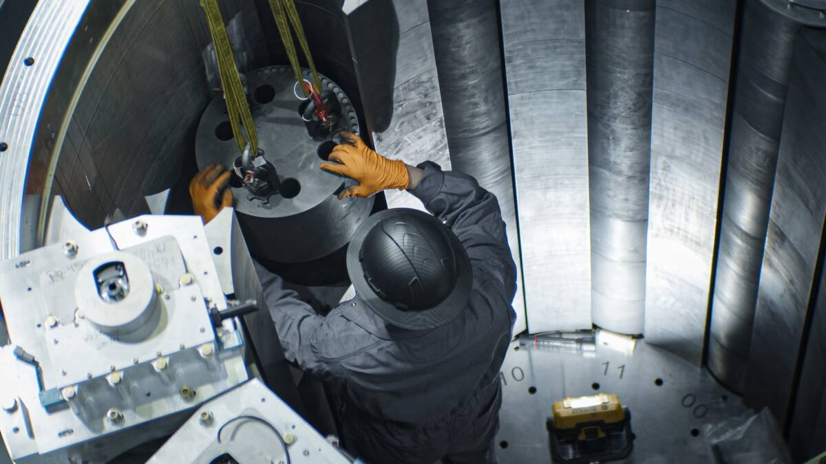 Работник в комбезе и шлеме собирает датчики ракеты Antares в тестовой лаборатории