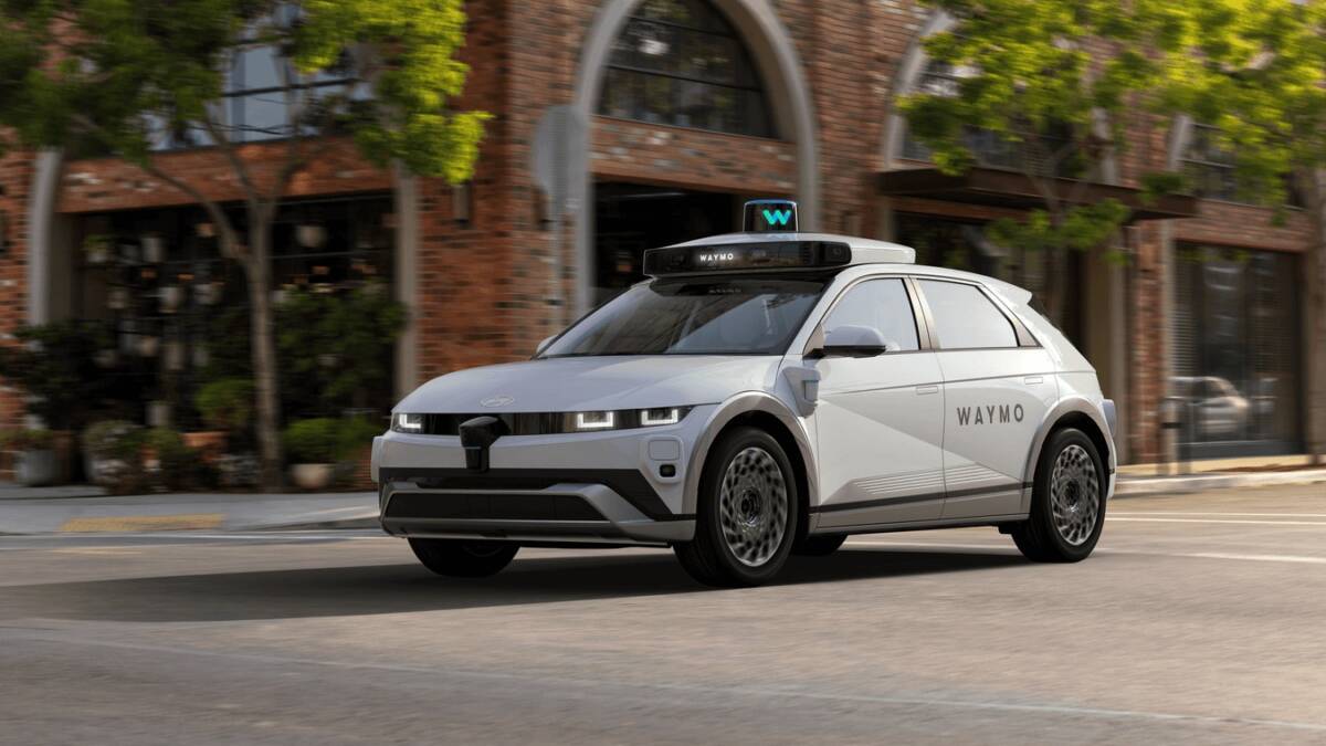 роботакси Waymo движется по улице с кирпичными домами