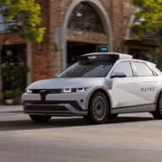 роботакси Waymo движется по улице с кирпичными домами
