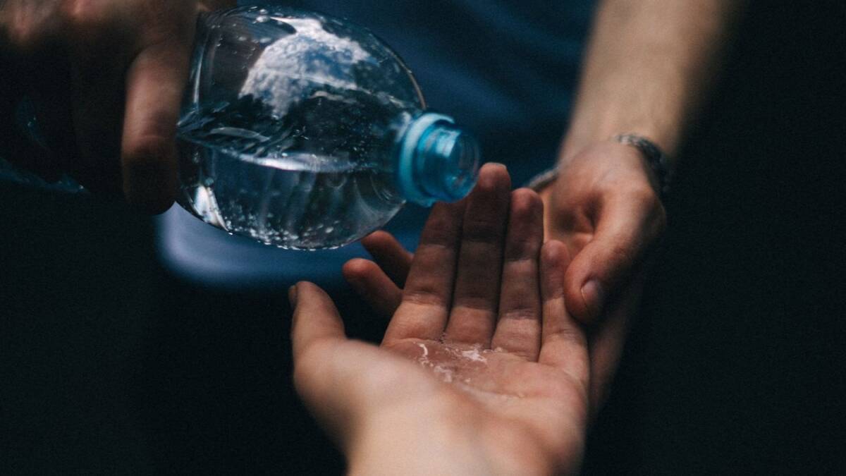 Пустая пластиковая бутылка для воды и рука человека