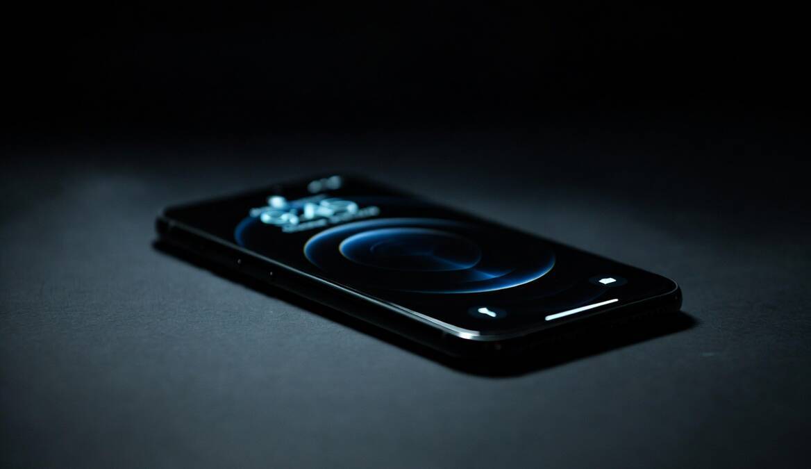 Черный смартфон Apple iPhone на темном фоне