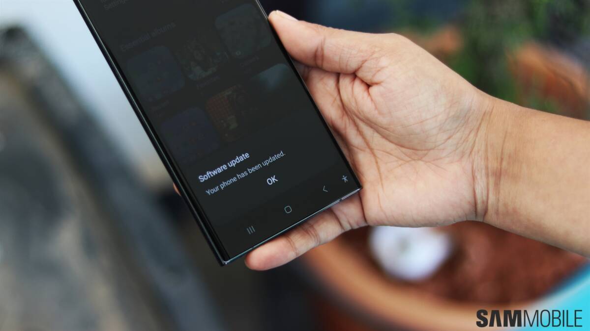 Человек держит смартфон Samsung Galaxy S23 с обновлением ПО