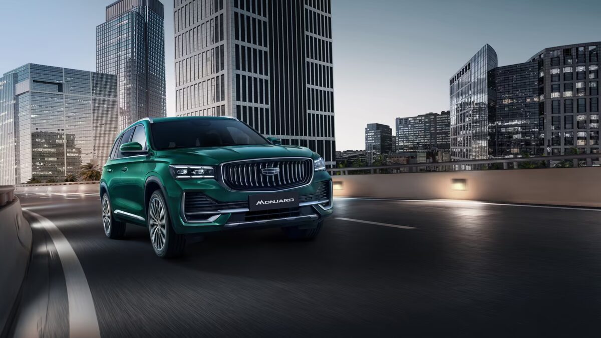 Зелёный кроссовер Geely Monjaro на дороге городского района