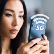 Девушка держит смартфон с значком 5G и Wi-Fi