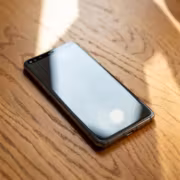 Смартфон Oppo Reno 16 Pro на деревянном столе