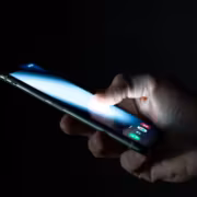 Рука держит смартфон с ярким экраном Snapdragon 8 Elite
