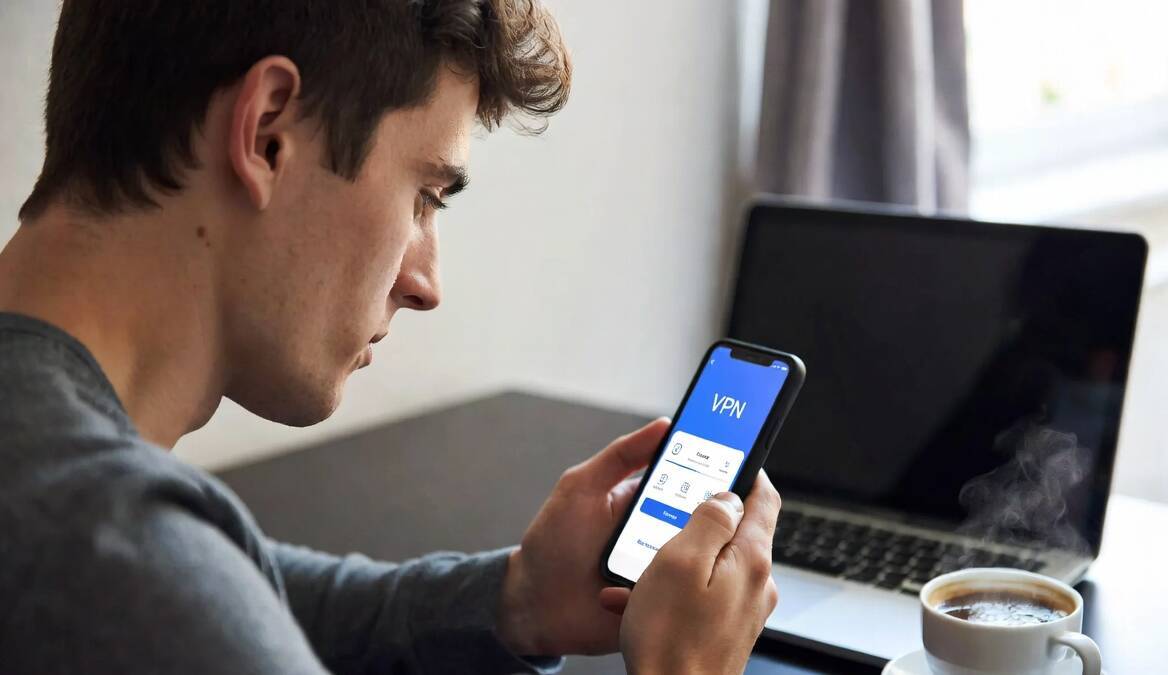 Мужчина использует телефон с VPN приложением Happ