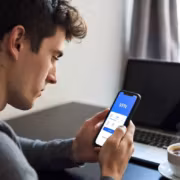 Мужчина использует телефон с VPN приложением Happ