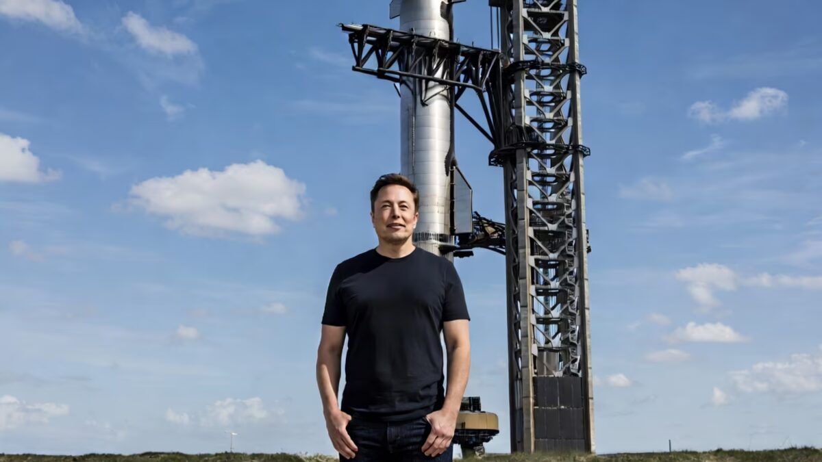 Мужчина в чёрной рубашке перед башней SpaceX