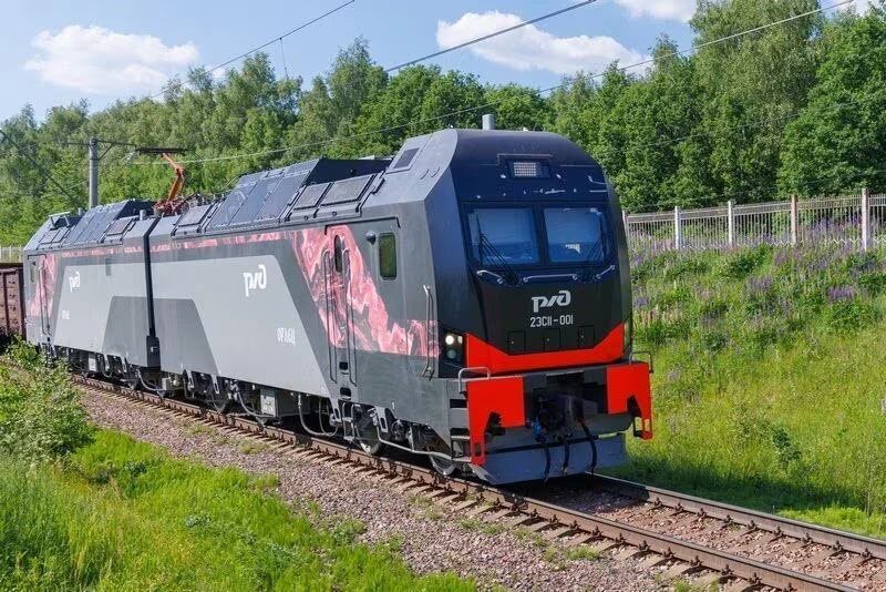 Электровоз 2ЭС11 Орлец движется по рельсам на зеленой лужайке