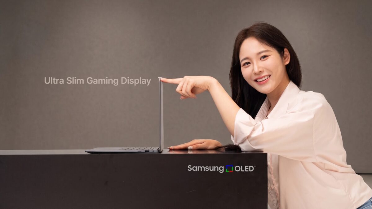 женщина держит тонкий ноутбук Samsung OLED