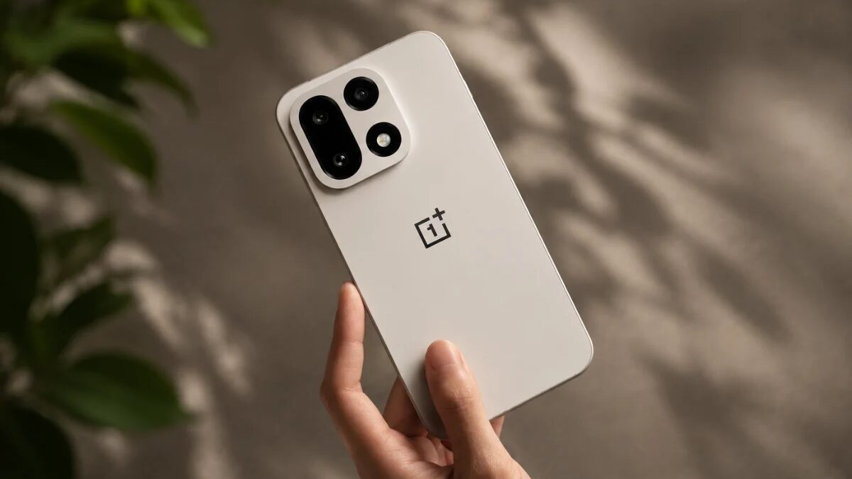Белый смартфон OnePlus 15 в руке человека