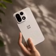 Белый смартфон OnePlus 15 в руке человека