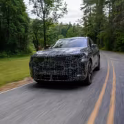 Автомобиль BMW X5 LWB на деревенской дороге летом