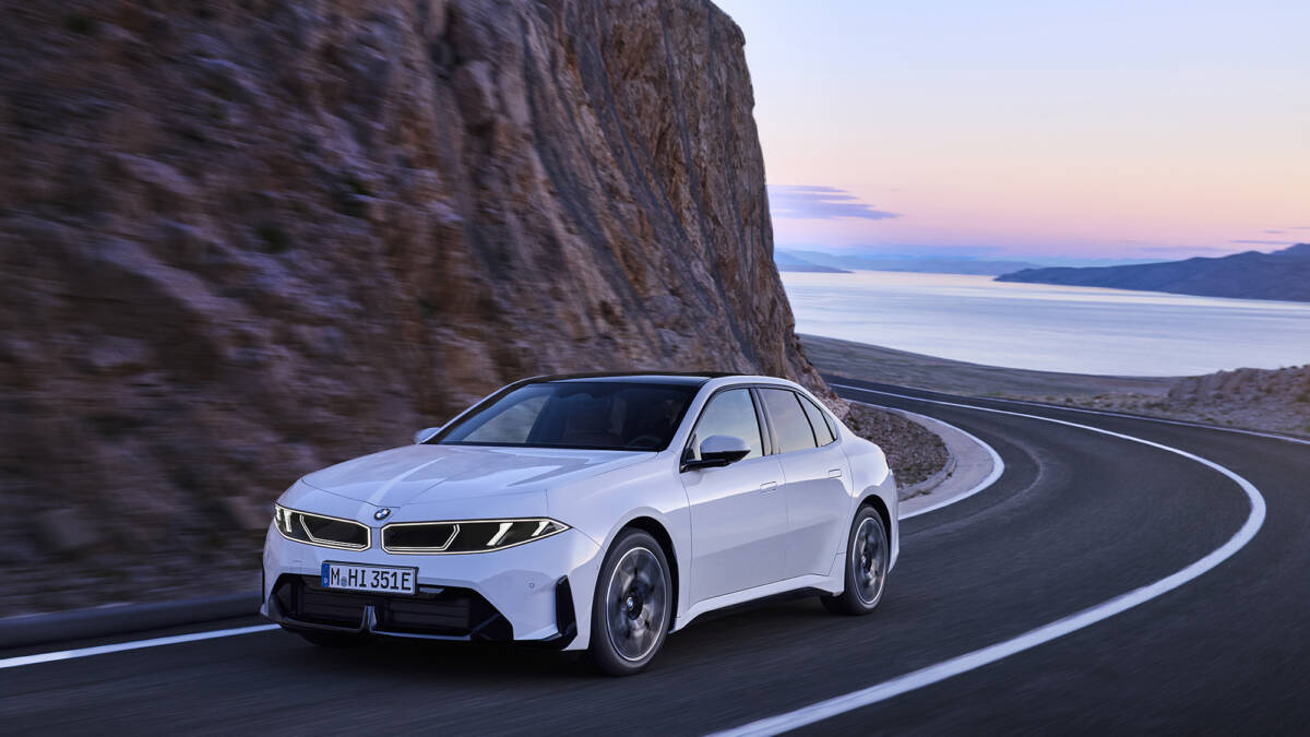 Электромобиль BMW i3 50 xDrive на дороге в горах