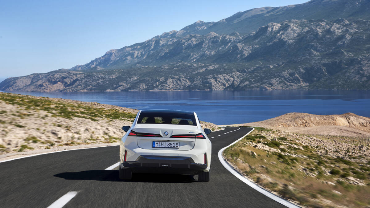 Электромобиль BMW i3 50 xDrive на дороге у озера