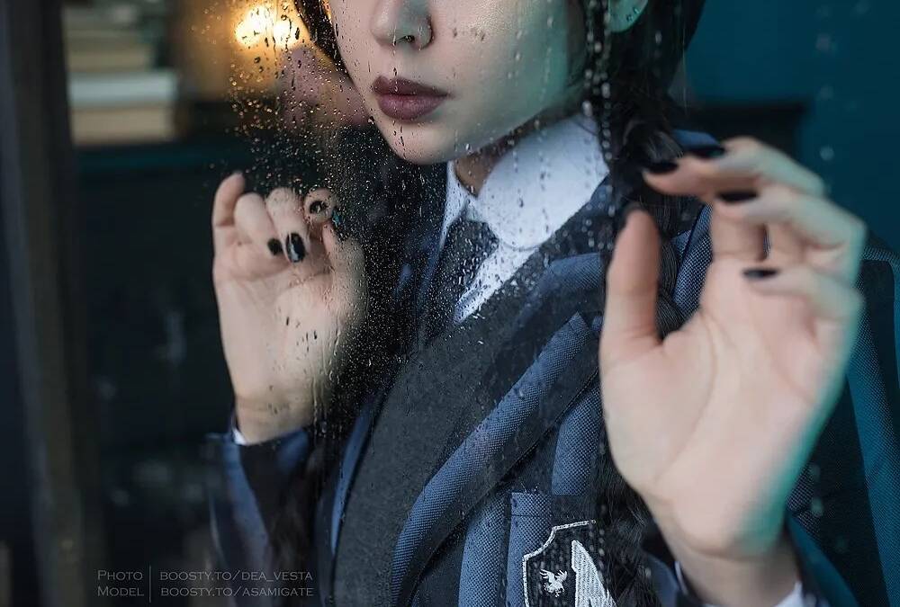 Русская модель показывает косплей Уэнсдэй из сериала Netflix через стекло