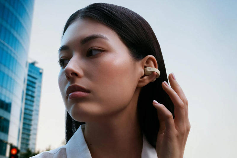 Красивая женщина с черными волосами и Sennheiser Accentum Clip на ухе