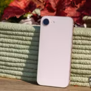 белый iPhone 17e стоит на деревянной поверхности у растения