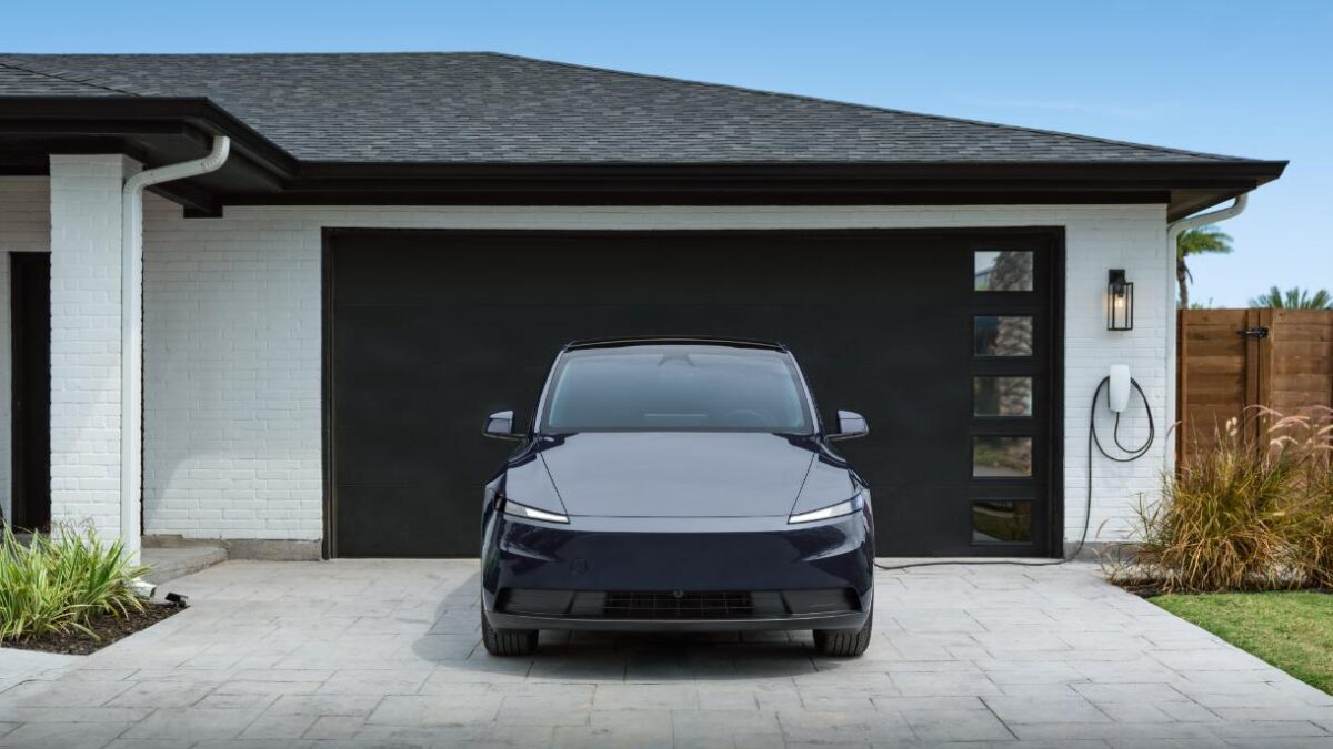 Электромобиль Tesla у гаража с автоматической парковкой