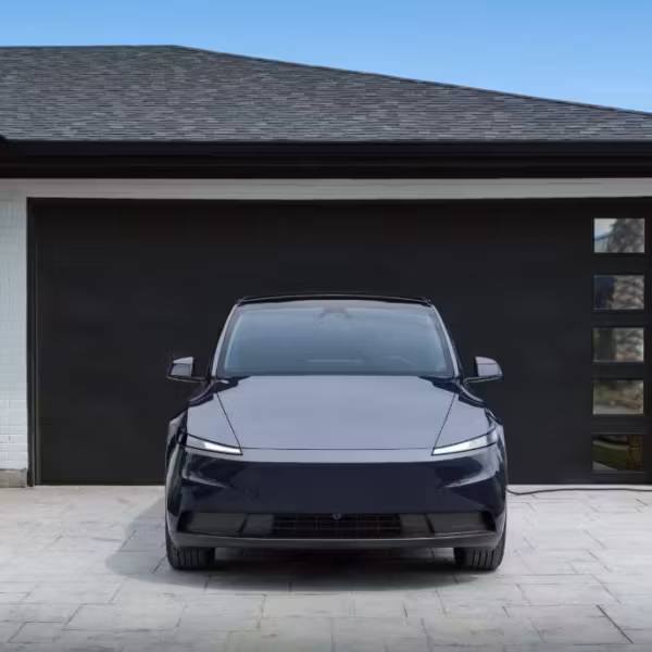 Электромобиль Tesla у гаража с автоматической парковкой
